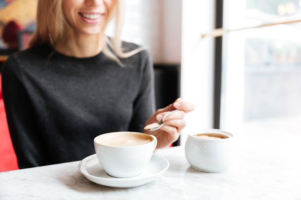 Cropped image of woman by the table with coffee - Foto, Bild
