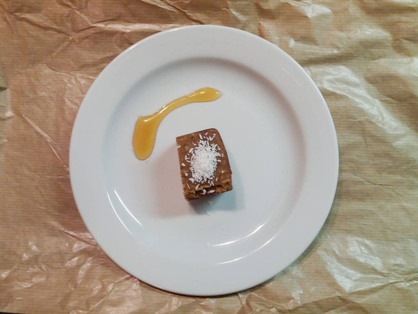 Pasta datilera con hojuelas de coco y postre de miel en un plato
 - Foto, imagen