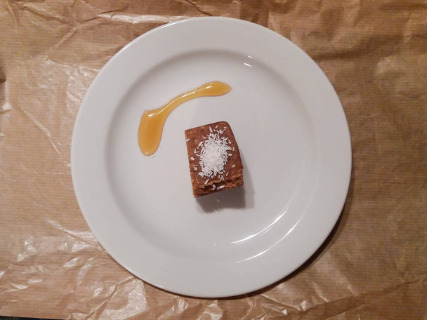 Datum pasta met kokos vlokken en honing dessert in een schotel - Foto, afbeelding