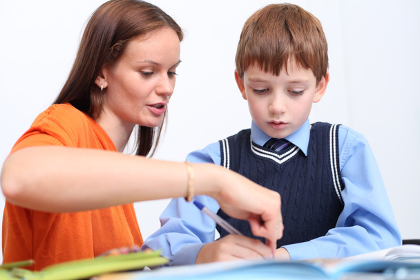 mother or teacher helping kid with schoolwork - Foto, Bild
