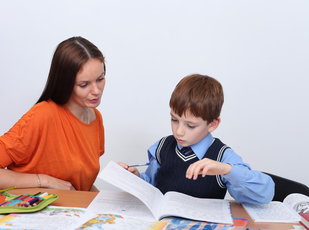 mother or teacher helping kid with schoolwork - Фото, изображение