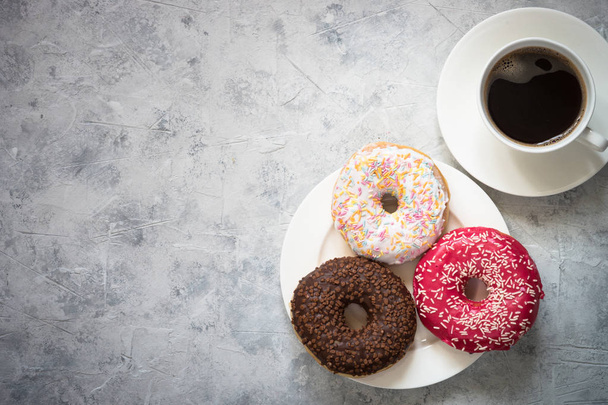 Colorful donuts at concrete table. - 写真・画像