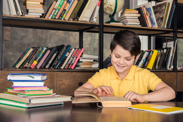 Schoolboy studying in library - Photo, Image