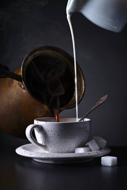 Cup of coffee with milk on dark background - Фото, зображення