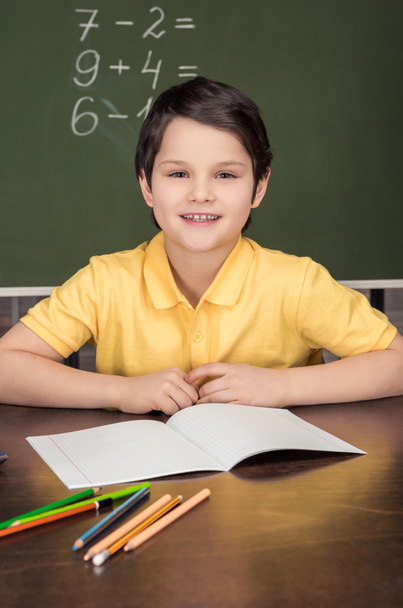 boy sitting at table in classroom - Фото, изображение