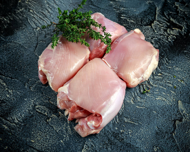 Сырой ассортимент Бескостные безволосые куриные бёдра с воском на каменном столе
 - Фото, изображение