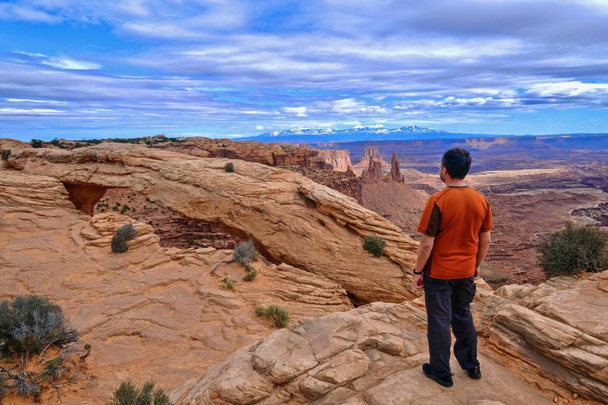 Man hiker on cliff looking at canyon views. ountains.  - Photo, Image