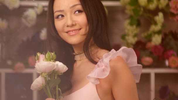 Woman and flowers. Asian girl portrait with bouquet - Video
