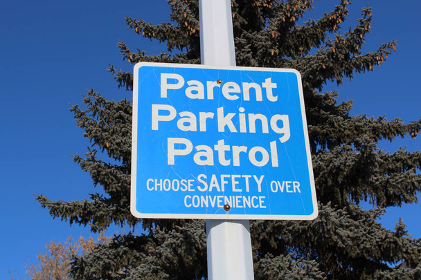 Γονέας στάθμευσης περιπολίας σημάδι κατά των δέντρων και το γαλάζιο του ουρανού - Φωτογραφία, εικόνα