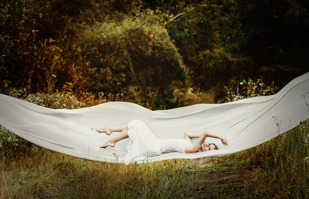 Левітація дівчина на білій тканині
 - Фото, зображення