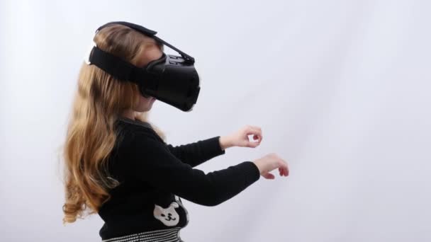A girl in a black blouse with black virtual reality glasses holds the handrail in front of her. Little girl sitting in a trolley on a roller coaster. - Footage, Video