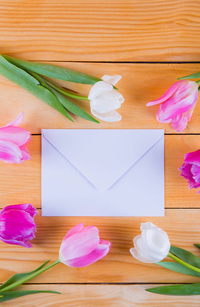 光菩薩の白い封筒で柔らかいピンクのチューリップの花束 - 写真・画像