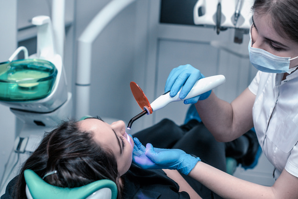 paciente do sexo feminino no dentista fazendo recheios dentários
 - Foto, Imagem