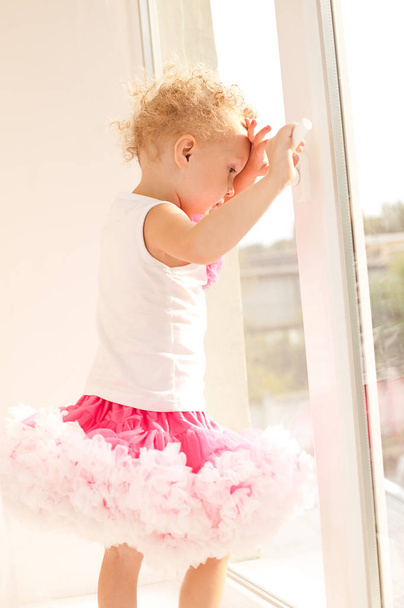 Malá holčička v nadýchané sukně stál u otevřeného okna. A - Fotografie, Obrázek
