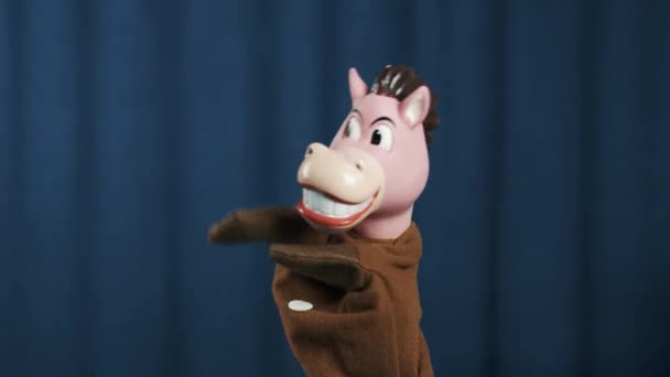 Horse hand puppet making money tossing gesture and shake head on blue background - Footage, Video
