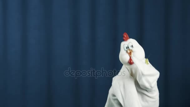 Maniquí de mano de pollo asintiendo con la cabeza y bailando en escena con fondo azul
 - Imágenes, Vídeo