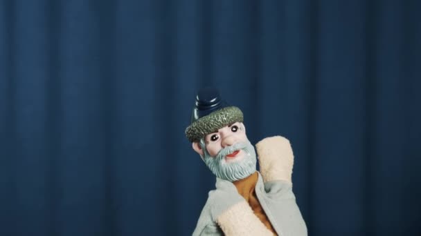 Handpuppe alter Mann, der Kopf schüttelt, wärmt die Menge auf der Bühne mit blauem Hintergrund - Filmmaterial, Video