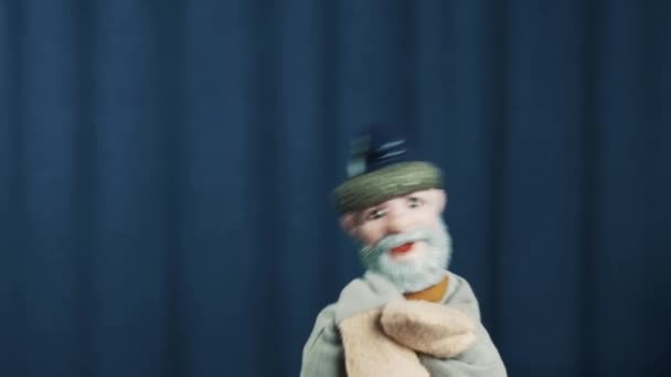 Elder man hand puppet shacking head repeatedly, dancing on scene blue background - Footage, Video