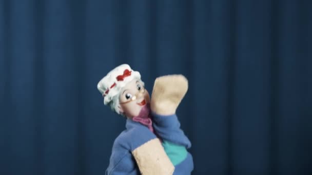 Stara kobieta pacynka pojawia się na scenie tańca gładkie ruchy na niebieskim tle - Materiał filmowy, wideo