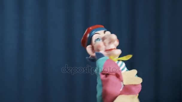 Jester hand puppet verschijnt op scène met blauwe achtergrond, groeten van publiek - Video