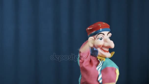 Petroesjka hand puppet wuivende arm vaarwel en lopen uit scène met blauwe achtergrond - Video