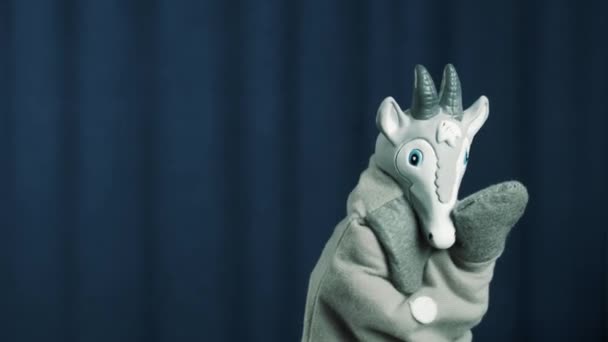 Goat hand puppet appears on scene with blue background, greeting audience - Footage, Video