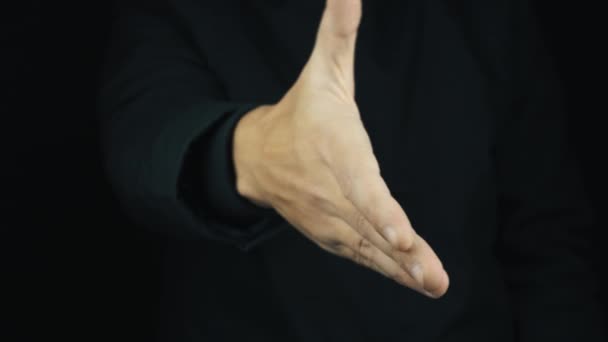 Hombre en chaqueta de manga larga extiende la mano derecha hacia adelante para el apretón de manos
 - Metraje, vídeo