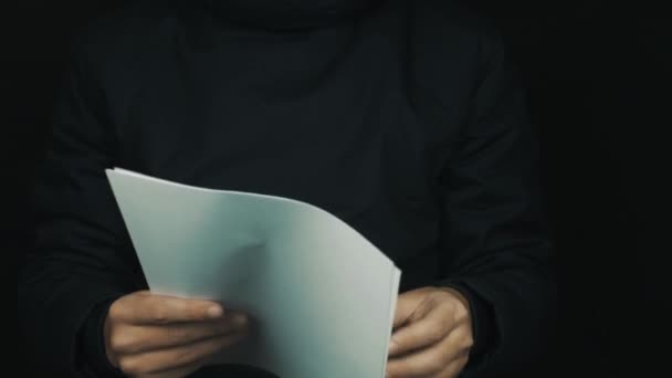 männliche Hand in Langarmjacke hält Papier, wirft und zerknüllt Blätter - Filmmaterial, Video