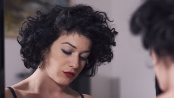 beautiful woman puts on red lipstick in front of mirror - Felvétel, videó
