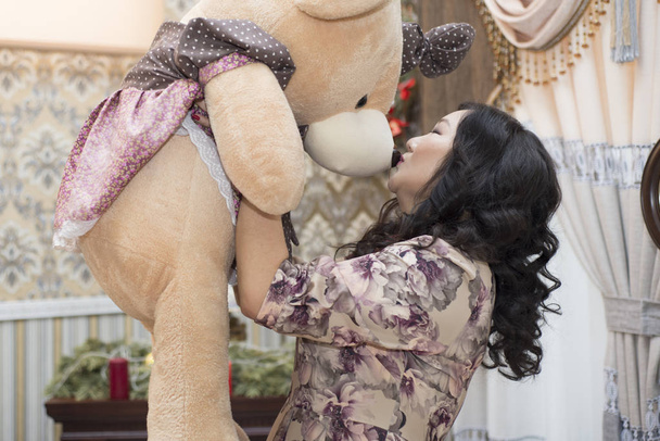 Full Asian woman holding and kissing a big Teddy bear. - Foto, imagen