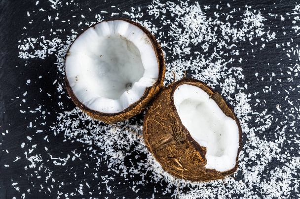 Two halves of coconut on black background - Photo, image