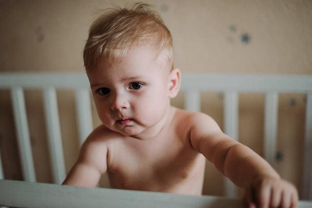 Baby boy smiling sitting in the crib just woke up - Fotografie, Obrázek
