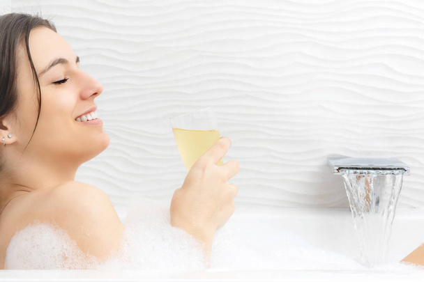 woman relaxing with champagne in bath - Photo, Image