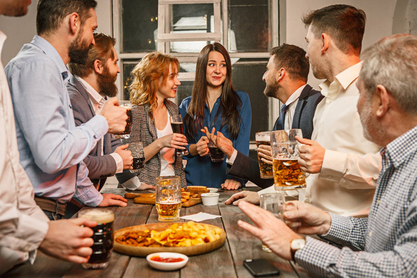 Group of friends enjoying evening drinks with beer - Фото, изображение