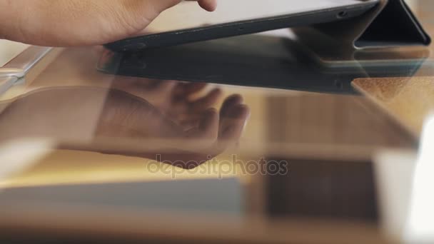 Mãos masculinas usando invólucro apresentado sobre mesa de café de vidro, jogando videogame
 - Filmagem, Vídeo