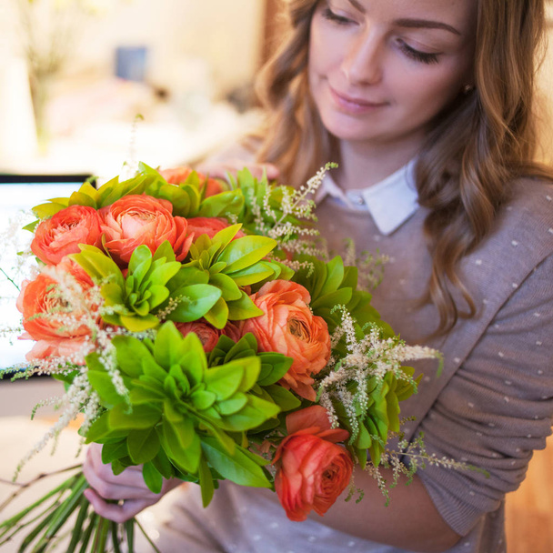 Flower delivery to the office. Young happy woman holding beautiful bouquet - Фото, зображення