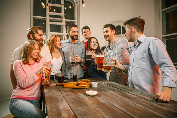 Group of friends enjoying evening drinks with beer - Valokuva, kuva