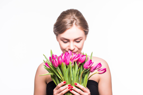 Retrato de una hermosa joven con cabello largo y maquillaje glamuroso. Chica sosteniendo tulipanes. Captura de estudio
. - Foto, imagen