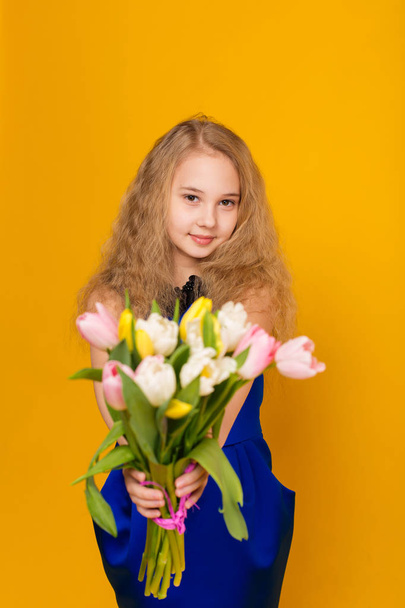 Beautiful girl with a bouquet of tulips  - Фото, зображення