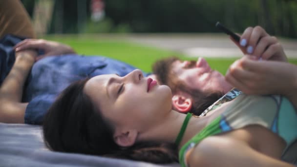 Una joven pareja descansando y hablando en el parque
. - Imágenes, Vídeo