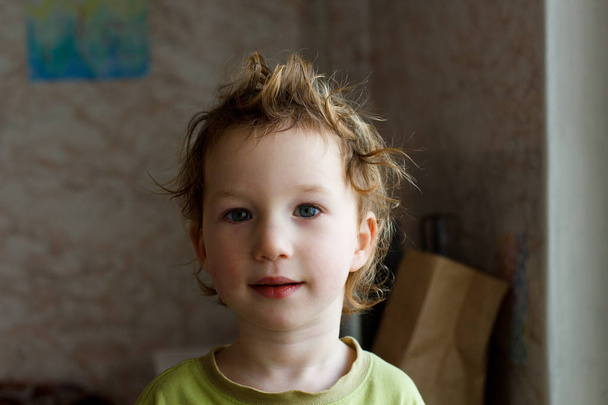 small boy sitting near window and thinking about something. He has beautiful great hair. Cute baby. - Fotó, kép