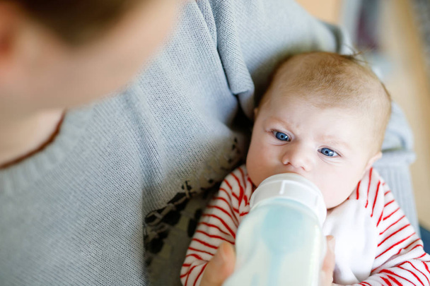 Father feeding newborn baby daughter with milk in nursing bottle - Φωτογραφία, εικόνα