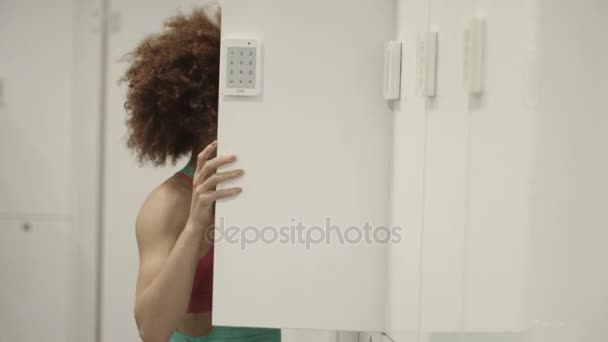 Genç kadın açılış dolabın içinde jimnastik salonu - Video, Çekim