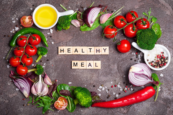 Свежие органические овощи, оливковое масло, травы и специи. Здоровое питание, здоровый образ жизни и концепция диеты. Смешайте салат, помидоры, чили и чеснок на каменном фоне. Кулинарный салат
 - Фото, изображение
