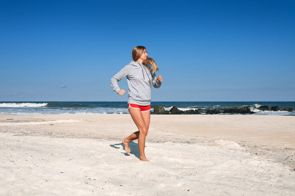 Женщина бежит по пляжу. Бегунья-женщина
. - Фото, изображение