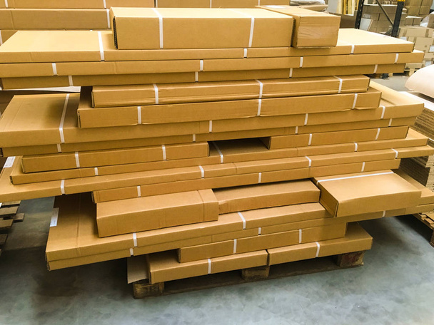 Shipment, logistics, delivery and product distribution business industrial concept: storage warehouse with row of stacked cardboard boxes with packed goods on wooden shipping pallets. - Photo, Image