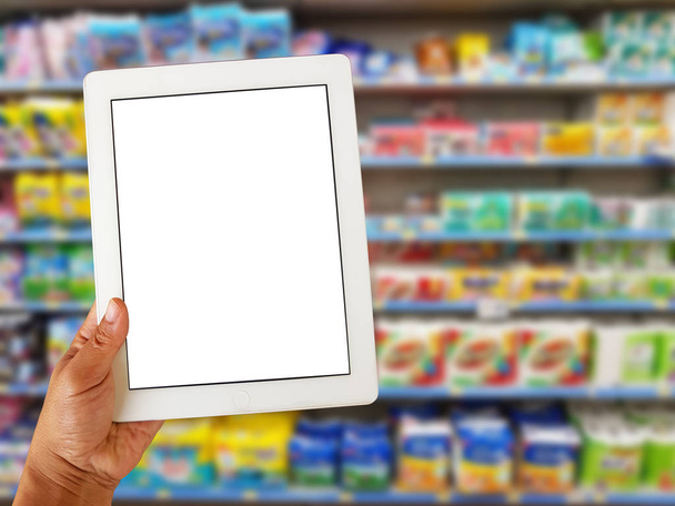 Asya sol eli boş tablet ekran üzerinde tutan çeşitli marka doku kağıt ve ambalaj süpermarket stand veya raf Satılık bebek bezi bulanık - Fotoğraf, Görsel
