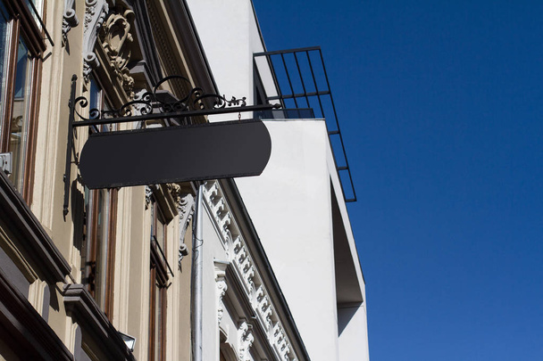 černý hranatý vývěsní štít na budově s klasickou architekturou - Fotografie, Obrázek