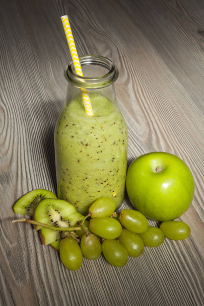 Batido de kiwi fresco con manzana y uvas en una botella
.   - Foto, Imagen