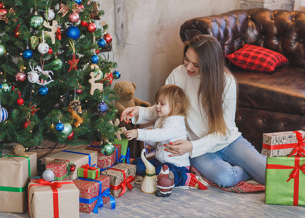 Happy mother and child decorating a Christmas tree - Foto, afbeelding